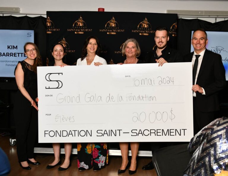 Six membres de la Fondation Saint-Sacrament tenant un grand chèque, montant de 20 000 $, Grand Gala, collecte de fonds, contribution pour les élèves, événement officiel, décor avec logo de la fondation, ambiance professionnelle, solidarité.