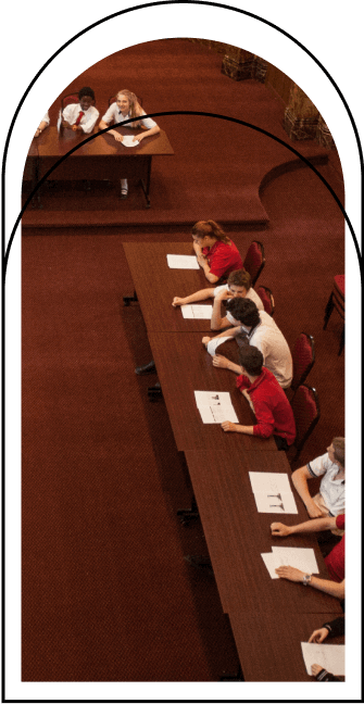 Étudiants assis à des tables, concentrés sur un exercice d’écriture, ambiance académique, concours ou activité scolaire, collaboration entre pairs, environnement éducatif, développement des compétences en rédaction et réflexion.